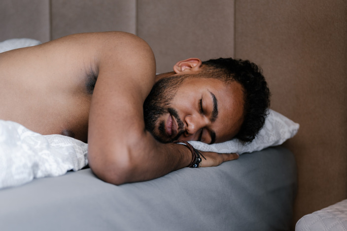 junger Mann liegt im Bett und schläft