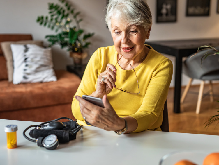 Ältere Dame, die auf ihr Smartphone schaut. 