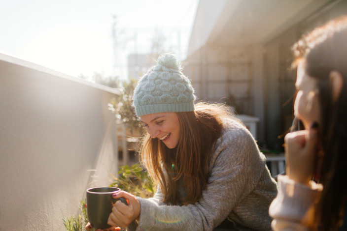 Zwei Frauen sitzen im Winter im Garten und trinken Tee.