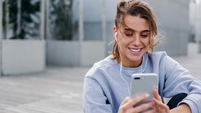 Junge Frau mit Handy in der Hand