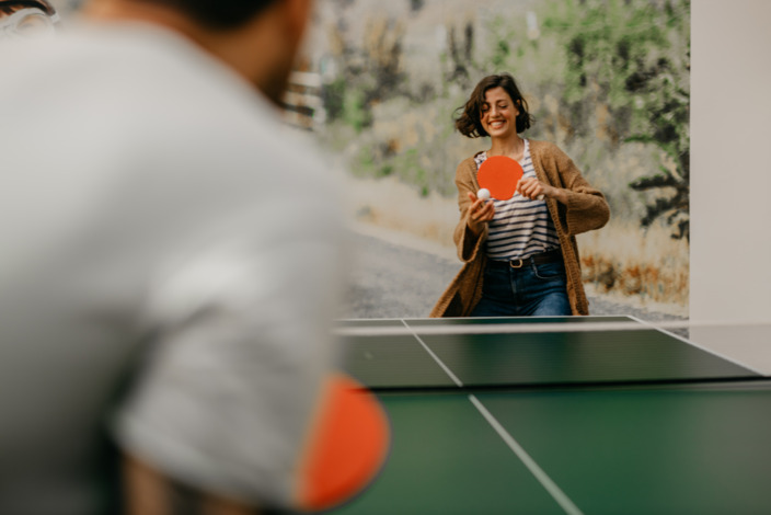 Lachende Frau spielt Tischtennis