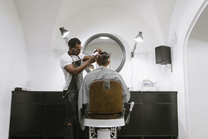 Friseur schneidet Kunden die Haare im Friseursalon