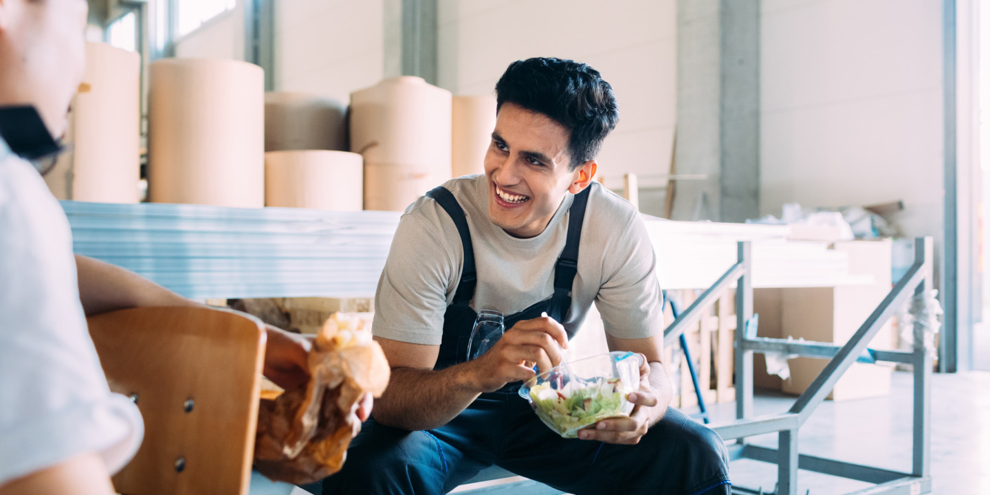 Handwerker macht Mittagspause mit einer gesunden Mahlzeit.