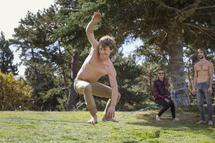 junger Mann beim Slacklinen im Park