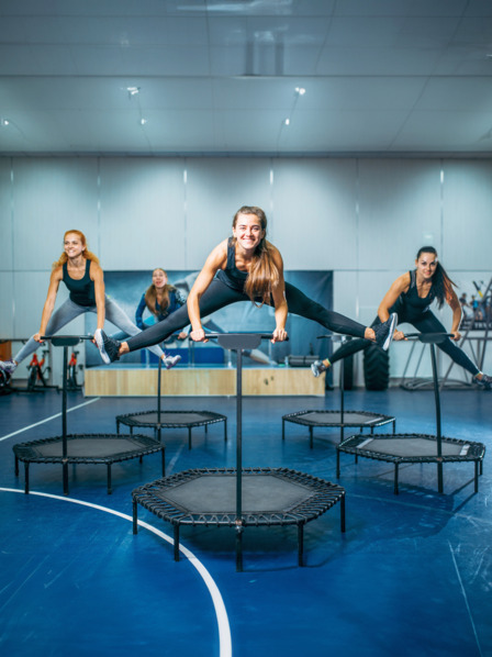 Frauen, die in einer Turnhalle auf Trampolinen springen