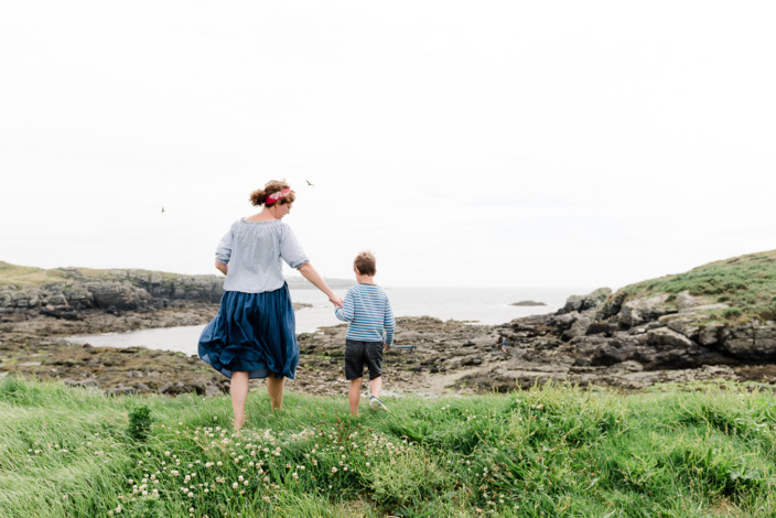 Mutter und Sohn wandern entlang eines Feldweges an der Küste