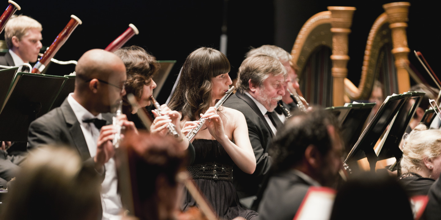 Eine Gruppe Musiker spielt Instrumente im Orchester. 