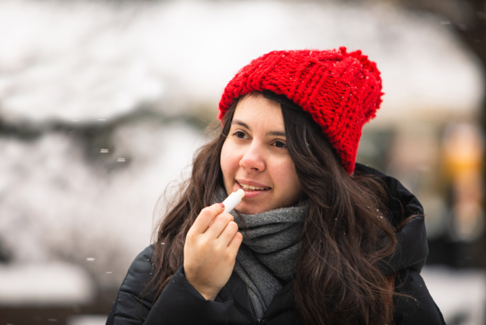 Frau pflegt ihre Lippen im Winter