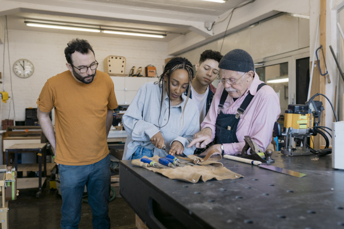 Diverse Handwerker:innen arbeiten zusammen in der Werkstatt