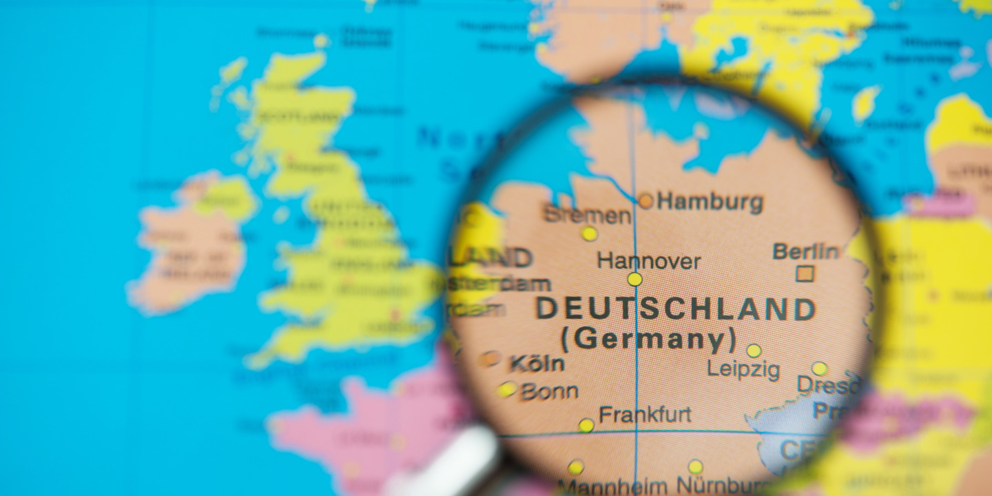 Weltkarte, auf der Deutschland mit einer Lupe vergrößert ist