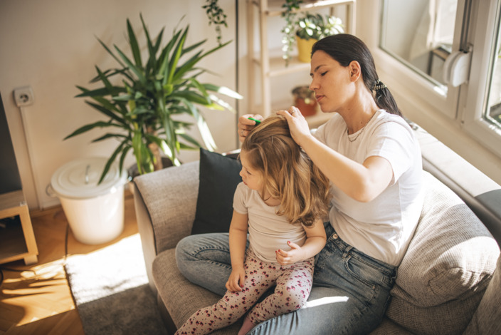 Mutter entlaust ihre Tochter zuhause auf der Couch