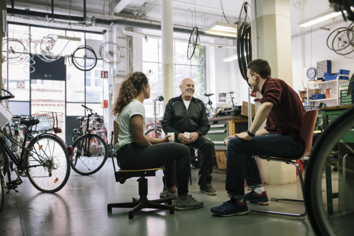 Gruppe von Fahrradmechanikern bespricht sich in der Werkstatt