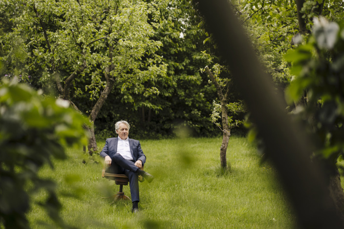 Mann sitz auf einem Stuhl auf einer Wiese