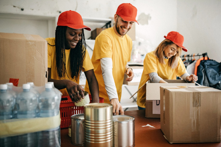 Junge Erwachsene voluntieren und helfen mit Lebensmitteln und packen.